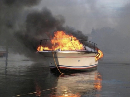 What should you do immediately if a boat motor catches fire?